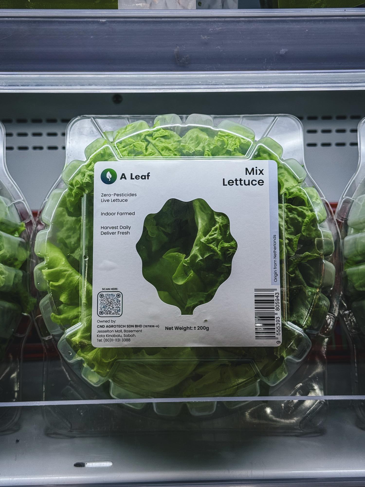 A Leaf Mix Lettuce retail clamshell with its zero-pesticides, indoor-farmed on-pack label